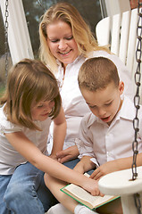 Image showing Young Boy Reads to His Mother and Sister