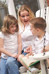 Image showing Young Boy Reads to His Mother and Sister