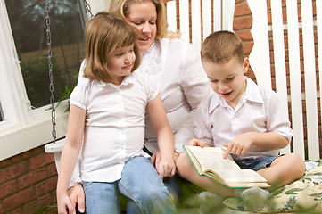 Image showing Young Boy Reads to His Mother and Sister