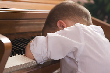 Image showing Young Boy with Head on the Piano