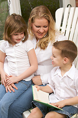 Image showing Young Boy Reads to His Mother and Sister