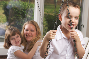 Image showing Young Boy Poses with Mom and Sister