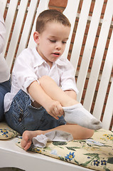 Image showing Adorable Young Boy Getting Socks On