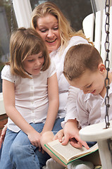 Image showing Young Boy Reads to His Mother and Sister