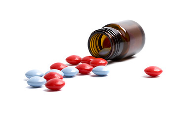 Image showing glass bottle with red and blue pills 
