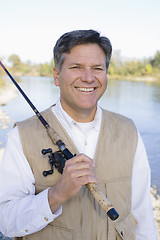 Image showing Man Standing With a Fishing Pole