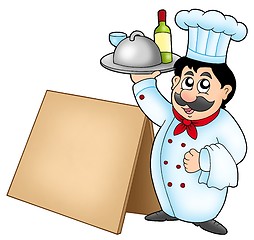 Image showing Chef holding meal with wooden table