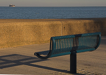 Image showing Green metal seat overlooking sea