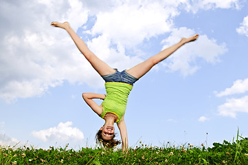 Image showing Young girl doing cartwheel