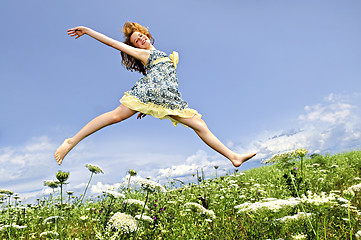 Image showing Young girl jumping in meadow