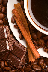 Image showing cup of coffee, beans, cinnamon and black chocolate