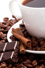 Image showing cup of coffee, beans, cinnamon and black chocolate