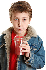 Image showing Child drinking fresh fruit juice through a straw