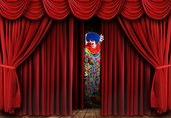 Image showing Creepy Clown Looking Through Stage Curtain Drapes