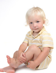 Image showing Innocent Child Sitting and Holding His Leg