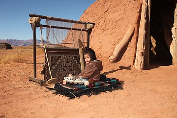 Image showing Navajo Child Sitting Next to Traditional Rug Making Tools