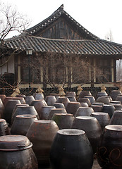 Image showing Kimchi pots in front of a traditional Korean home