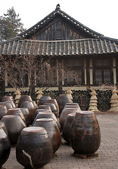 Image showing Kimchi pots in front of a traditional Korean house