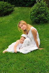 Image showing Young mother and daughter resting in meadow