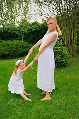 Image showing Young mother and daughter playing in meadow