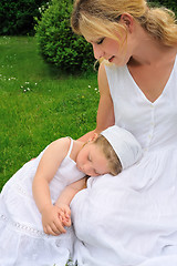 Image showing Young mother and daughter resting in meadow