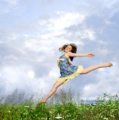 Image showing Young girl jumping in meadow