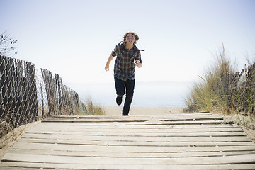 Image showing Boy Running On Beach Walkway