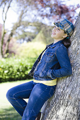 Image showing Tween Girl Leaning Against Tree In Park