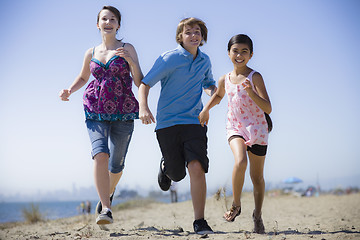 Image showing Three Kids Running on Beach