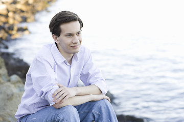 Image showing Teenage Boy Sitting by Water