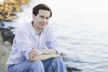 Image showing Teenage Boy Sitting on Rocks