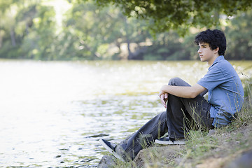 Image showing Teen Boy Sitting By Lake