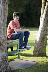 Image showing Smiling Teenage Boy Sitting on Bench