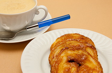 Image showing Closeup of coffee with milk in white cup and a palmier pastry