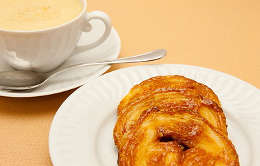 Image showing Closeup of coffee with milk in white cup and a palmier pastry