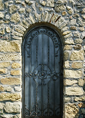 Image showing old iron door in the ancient stone wall