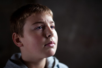 Image showing Young boy looking up with hope and despair in his eyes 