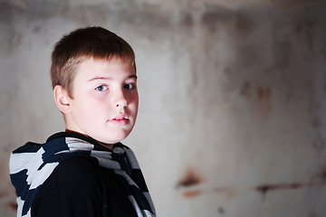 Image showing Boy looking over the shoulder against grunge background lit with 3 flashes