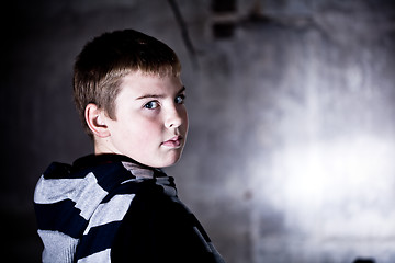 Image showing Boy looking over the shoulder against grunge background lit with flash High contrast