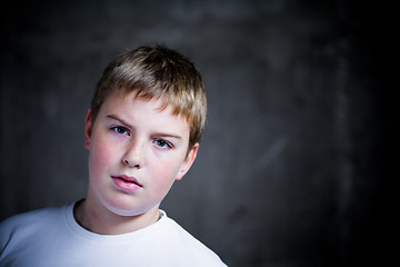 Image showing Handsome teenaiger looking self assured at camera portrait underexposed 