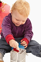 Image showing Cute Little girl playing with christmas presents