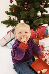 Image showing Shhh - Cute baby sneakily opening christmas gifts