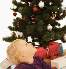 Image showing Christmas Time - Cute kid looking up at christmas tree
