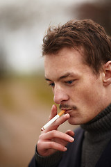 Image showing Trendy young man smoking an unhealthy cigarette