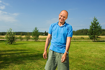 Image showing Middle-aged man smiling on a grass   