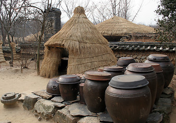 Image showing Kimchi (pickled cabbage) pots outside at straw tent