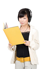 Image showing Asian girl in headphones with yellow book