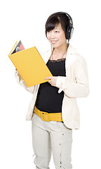 Image showing Asian woman with yellow book and headphones