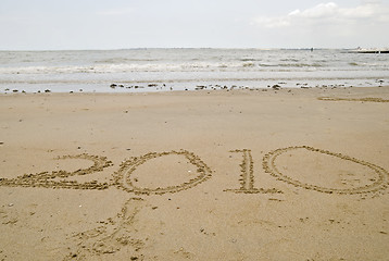 Image showing 2010 written in the sand.