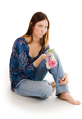 Image showing Woman depressed siting on the flor with flowers in hand